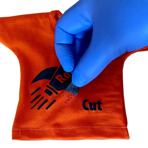 Hånd som plukker folie av en orange t-skjorte